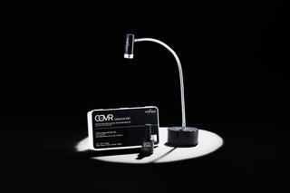 COVR Tips professional system. COVR DisCOVR Tip Set, UnderCOVR Soft Gel Base, & OVRHead Lamp in a white spotlight with black contrasting background.