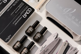 Set of nail care products in an open desk drawer, including gel polis bottles, files, buffers, and professional gel nail products.